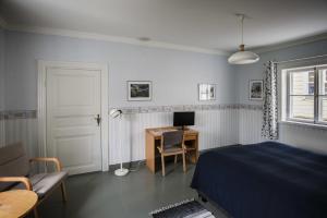 Un dormitorio con una cama y un escritorio con una computadora. en Motel Marine, en Tammisaari