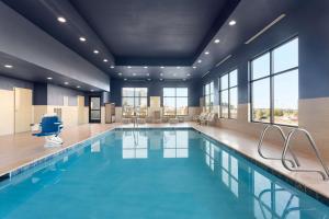 una piscina con agua azul en una habitación con ventanas en Hampton Inn by Hilton Kennewick at Southridge, en Kennewick