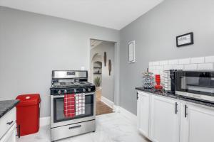 a kitchen with a stove and a microwave at Modern & Cozy East Side Gem ~ Queen Beds ~ Parking in Detroit