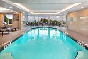 a large pool with blue water in a hotel lobby at Hilton Garden Inn Halifax Airport in Enfield