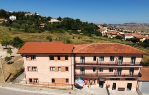 a large building with a red roof on a hill at Pianisi Albergo in SantʼElia a Pianisi