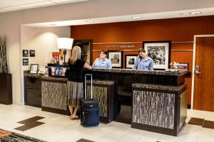 three people standing at a bar in a hotel lobby at Hampton Inn & Suites Tulsa/Tulsa Hills in Tulsa