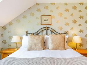 a bedroom with a white bed with two lamps at The Hayloft in Lostwithiel