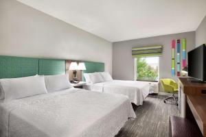 米德韦斯特城Hampton by Hilton Oklahoma City I-40 East- Tinker AFB的一间有两张床和一台平板电视的酒店房间