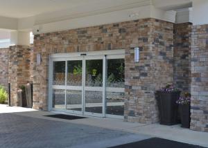 a brick building with sliding glass doors on it at Hampton Inn & Suites Philadelphia/Media in Media
