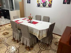 a dining room table with chairs and a white table cloth at Cuzco A 5 min del centro histórico¡Apartamento completo! in Cusco