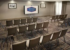 Hampton Inn & Suites Philadelphia/Media في ميديا: مجموعة كراسي في غرفة بشاشة