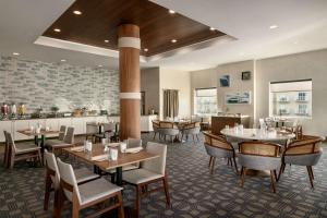 un restaurante con mesas y sillas y un bar en Hilton Suites Ocean City Oceanfront, en Ocean City