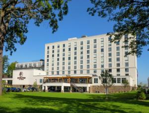 a large white building with a green park at DoubleTree by Hilton Hotel Niagara Falls New York in Niagara Falls