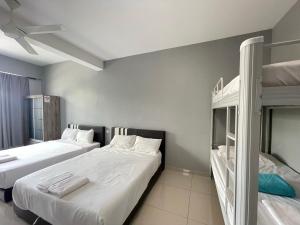 two beds in a room with two bunk beds at Reno Hotel Ipoh in Ipoh