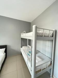 a room with two bunk beds with white sheets at Reno Hotel Ipoh in Ipoh