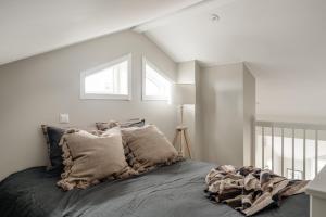 a white bedroom with a bed with pillows at Modern nybyggd lägenhet i Orsa Grönklitt in Orsa