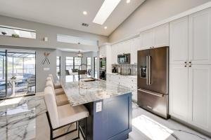 a kitchen with white cabinets and a stainless steel refrigerator at Luxurious Cape Coral Oasis Half Mi to Boat Ramp! in Cape Coral