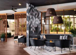 een lobby met een zwarte bank en stoelen bij Hilton Myrtle Beach Resort in Myrtle Beach