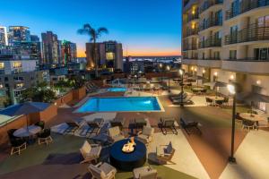 uma imagem de um pátio no último piso com uma piscina, mesas e cadeiras em DoubleTree by Hilton San Diego Downtown em San Diego