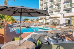 ein Pool mit Stühlen und einem Sonnenschirm neben einem Hotel in der Unterkunft DoubleTree by Hilton San Diego Downtown in San Diego