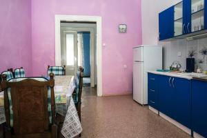 Una cocina con paredes moradas y una mesa y un refrigerador. en Apartments Martinetti, en Herceg-Novi