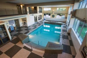 - une vue sur la grande piscine située dans un bâtiment dans l'établissement Hilton Winnipeg Airport Suites, à Winnipeg