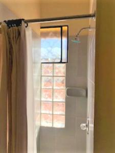 - un rideau de douche dans la salle de bains pourvue d'une fenêtre dans l'établissement Casa Carmel Bed & Breakfast, à Guatemala