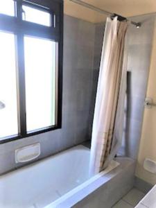 uma casa de banho com uma banheira, uma janela e um chuveiro em Casa Carmel Bed & Breakfast em Guatemala