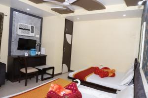 a bedroom with a bed and a desk and a tv at Hotel Mittal Inn in Ajmer