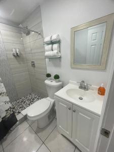 uma casa de banho com um WC, um lavatório e um chuveiro em tranquilo y fantastico apartamento cerca de playas y areopuerto em Tampa