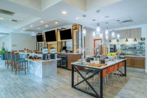 a large kitchen with a counter with chairs and tables at Hilton Garden Inn Augusta in Augusta