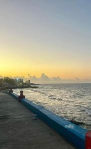 um cais na praia com o oceano ao pôr do sol em Villas Bliss 18 em Ilha das Mulheres