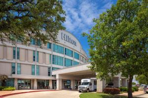 a building with a truck parked in front of it at Hilton Austin Airport in Austin