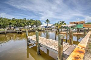 ein Dock auf einem Wasserkörper mit Gebäuden im Hintergrund in der Unterkunft Everglades City Trailer Cabin with Boat Slip! in Everglades City