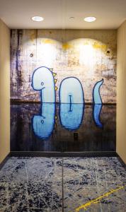a wall with blue graffiti on it in a room at Hilton Austin Airport in Austin