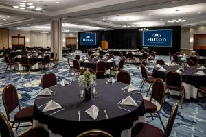 a conference room with tables and chairs and a stage at Hilton Austin Airport in Austin