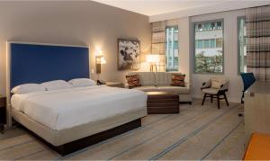 a bedroom with a large white bed and a couch at Hilton Austin Airport in Austin