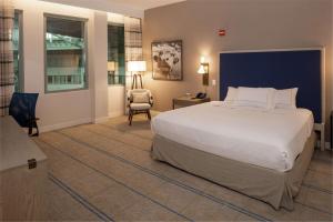 a bedroom with a large white bed and a chair at Hilton Austin Airport in Austin
