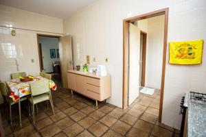 a room with a table and a kitchen with a mirror at NOVIDADE Apto na Praia do Morro em Guarapari ES in Guarapari