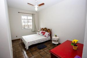 a bedroom with a bed and a window and a red table at NOVIDADE Apto na Praia do Morro em Guarapari ES in Guarapari
