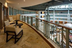 a balcony with chairs and tables on a building at Hilton Austin Airport in Austin