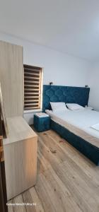 a bedroom with a bed and a wooden floor at LukAmi Green Home in Făgăraş