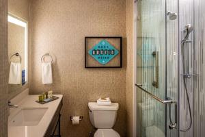 a bathroom with a toilet and a sign on the wall at Hilton Austin Airport in Austin