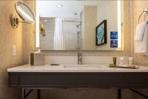 a bathroom with a sink and a mirror at Hilton Austin Airport in Austin