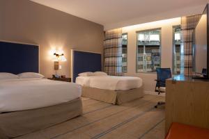 a hotel room with two beds and a desk at Hilton Austin Airport in Austin