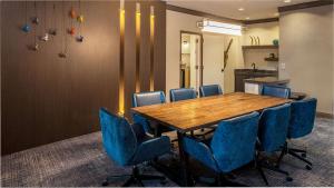 a conference room with a wooden table and blue chairs at Hilton Austin Airport in Austin