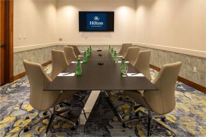 a conference room with a long table and chairs at Hilton Austin Airport in Austin