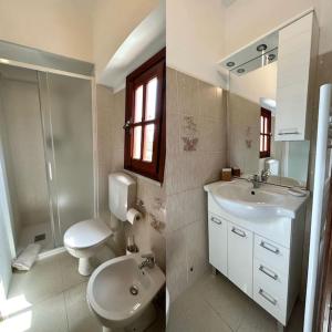 bagno con servizi igienici, lavandino e specchio di La casa di Carlotta a Loano