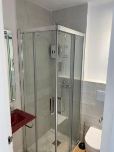 a glass shower in a bathroom with a toilet at Gaudi Street Apartments in Sitges