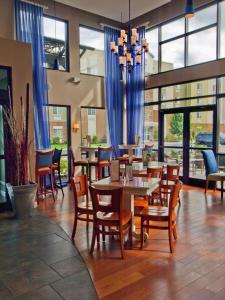 a restaurant with tables and chairs and blue curtains at DoubleTree by Hilton Buffalo-Amherst in Amherst