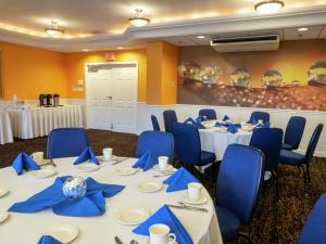 una sala de conferencias con mesas blancas y sillas azules en DoubleTree by Hilton Buffalo-Amherst en Amherst