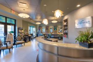 a lobby of a salon with chairs and a counter at The Mosey Buffalo Williamsville Tapestry Collection Hilton in Williamsville