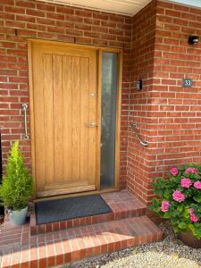 a wooden front door of a brick house with flowers at Studio 33 in Chichester