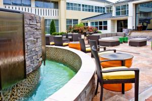 a pool with chairs and tables in a patio at DoubleTree by Hilton Huntsville-South in Huntsville